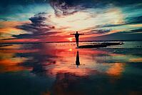 Person greeting sunrise on the water